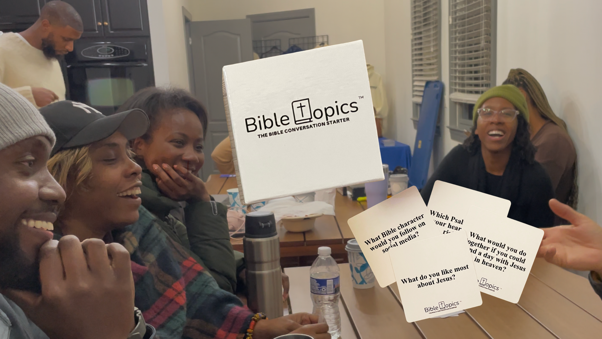 Group of people sitting around a table with 'Bible Topics' cards and box.